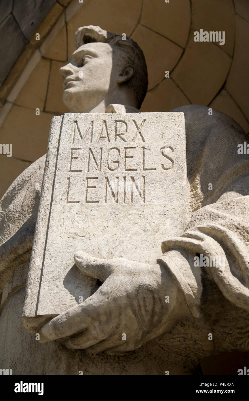 Portrait model worker sculpture holding book with names of Marx, Engels, Lenin and Stalin's name being erased after 1956 of Palac Kultury i Nauki PKiN Stock Photo