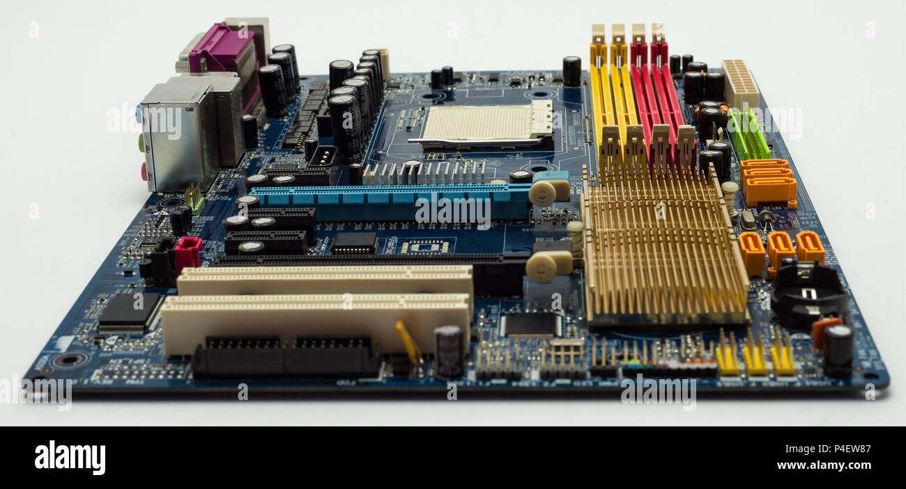 Motherboard with visible PCI express connector slot, heat sink, memory slot, cpu socket in blue. Stock Photo