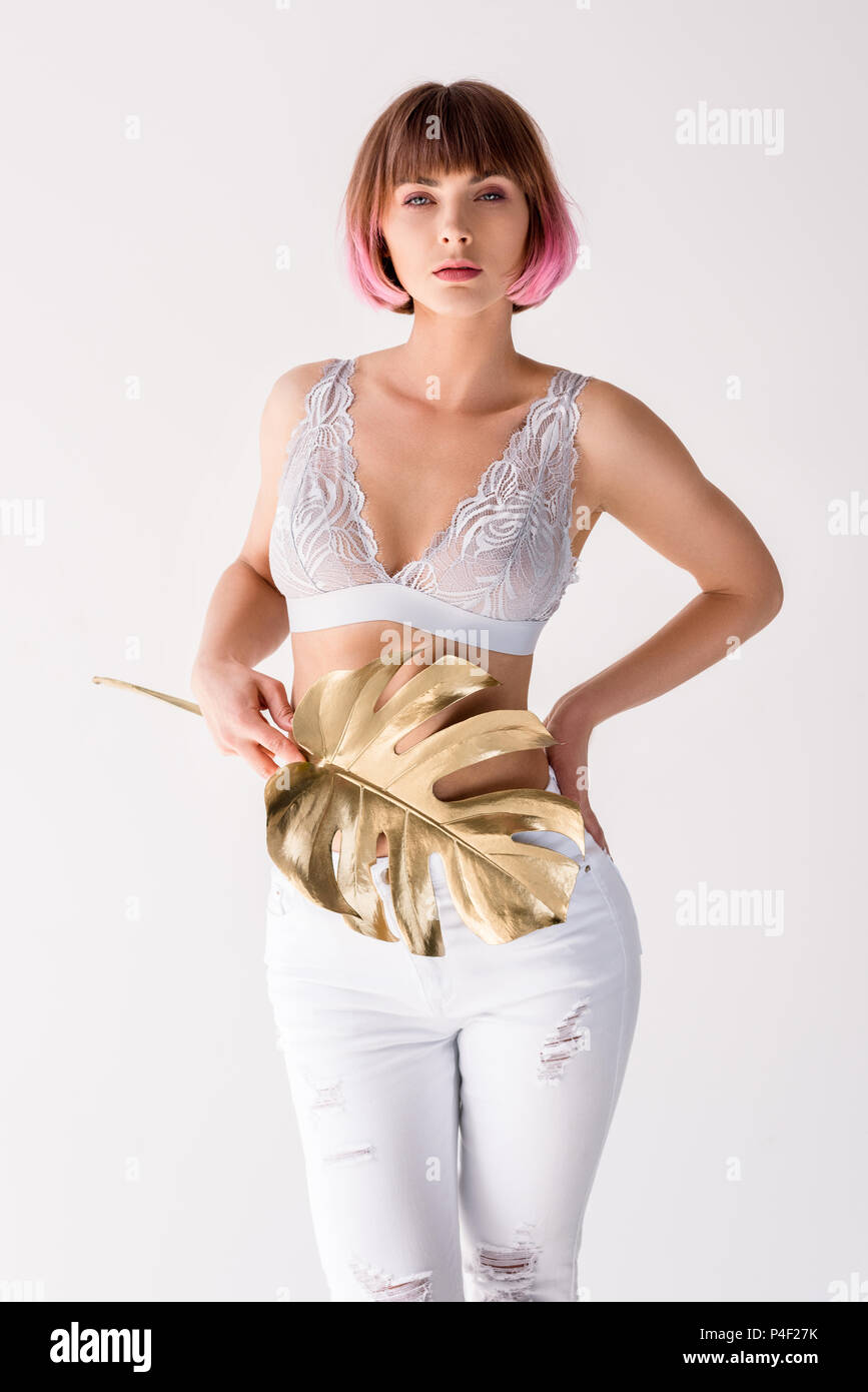 Young woman in lace bralette posing with golden palm leaf in her hand and  looking at camera Stock Photo - Alamy