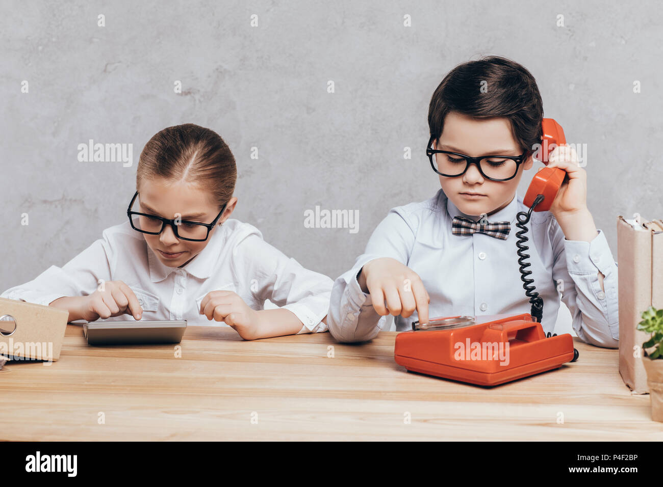 portrait of concentrated children in eyeglasses working together at workplace Stock Photo