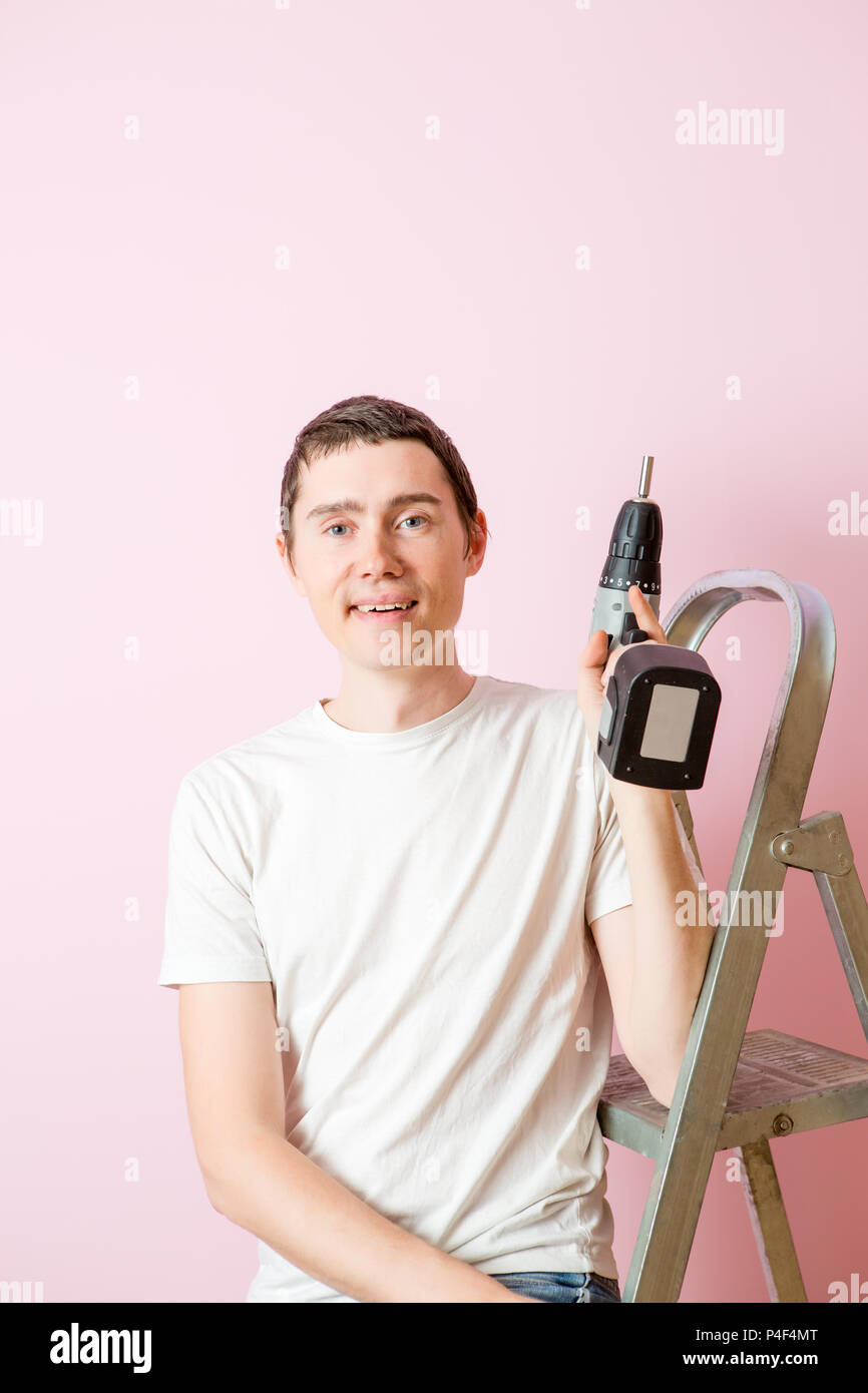 Image of man with drill near ladders Stock Photo Alamy