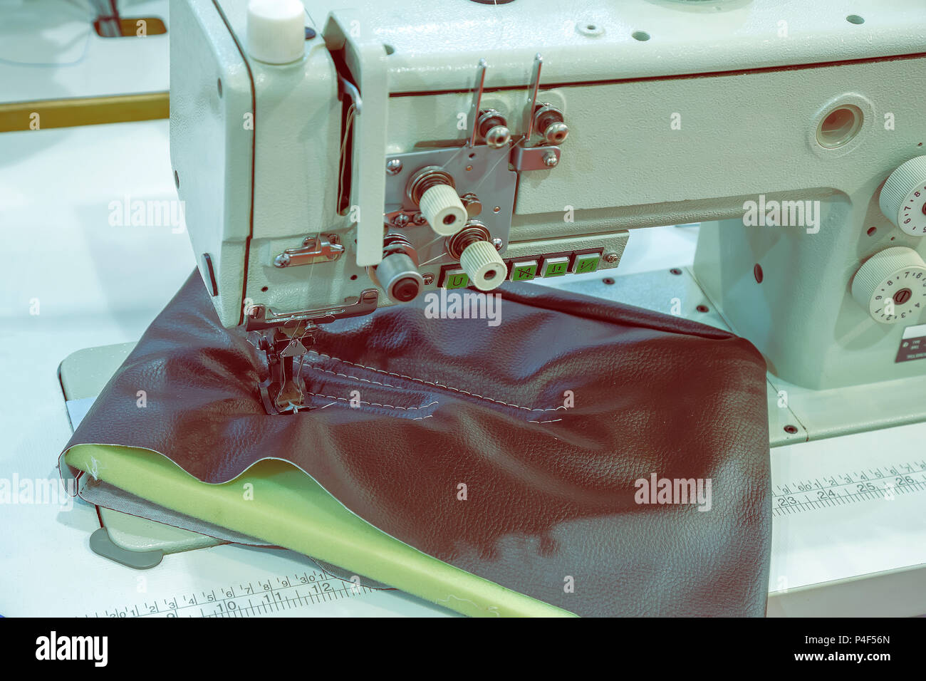 Industrial sewing machine head and item of clothing. Selective focus