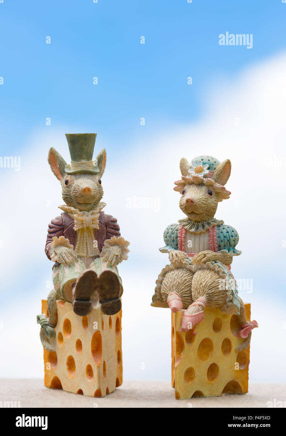 Cute bride & groom ornaments (mice) given as wedding gift to the special couple on their special day; outdoors shot with blue sky & fluffy clouds. Stock Photo