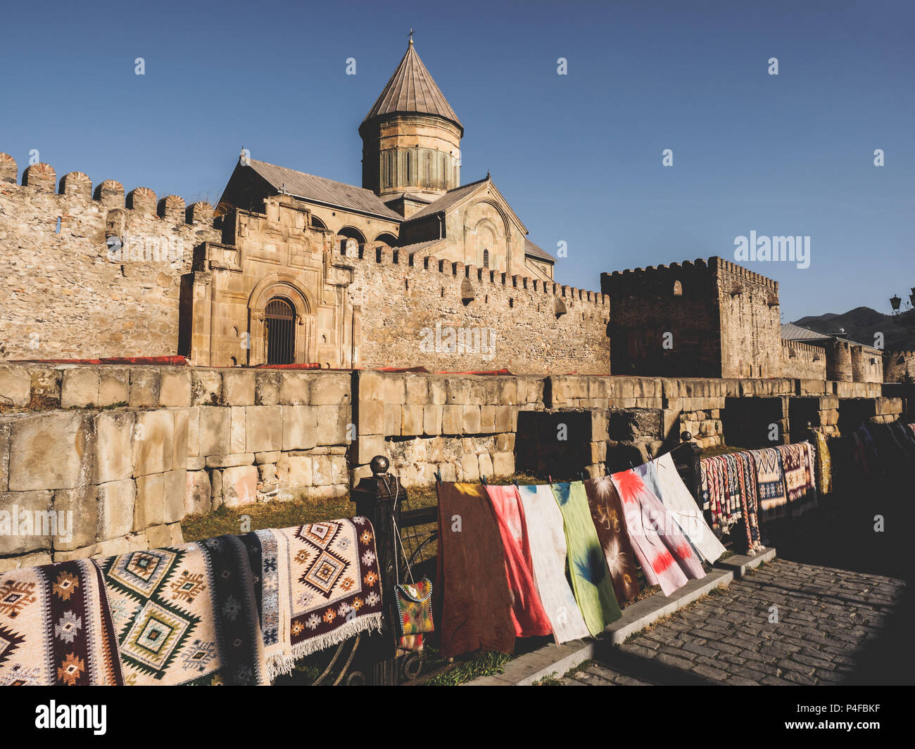 scenic view of ancient architecture and outdoor market with carpets in Georgia Stock Photo