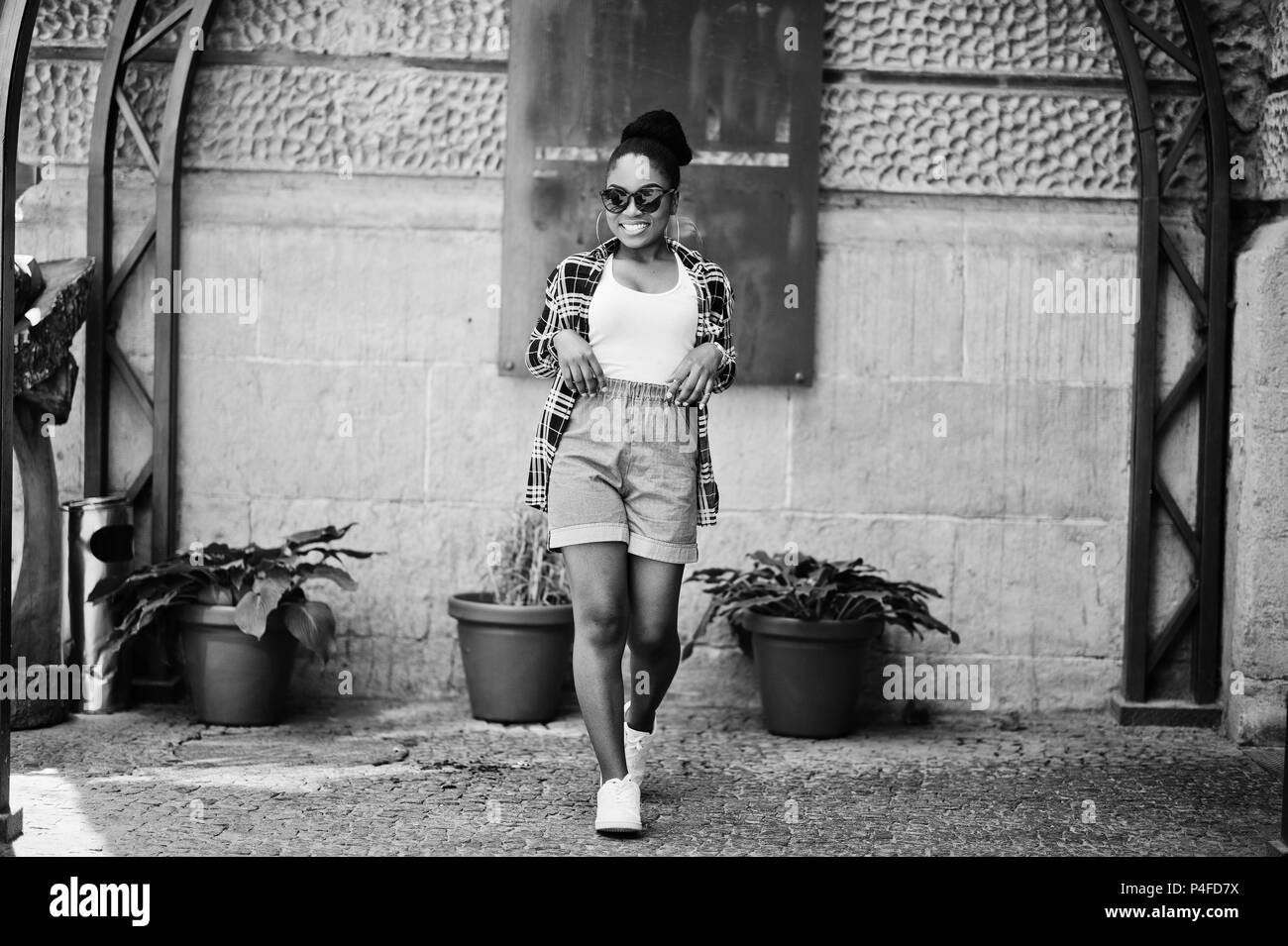 Hip hop african american girl on sunglasses and jeans shorts. Casual street fashion portrait of black woman. Stock Photo