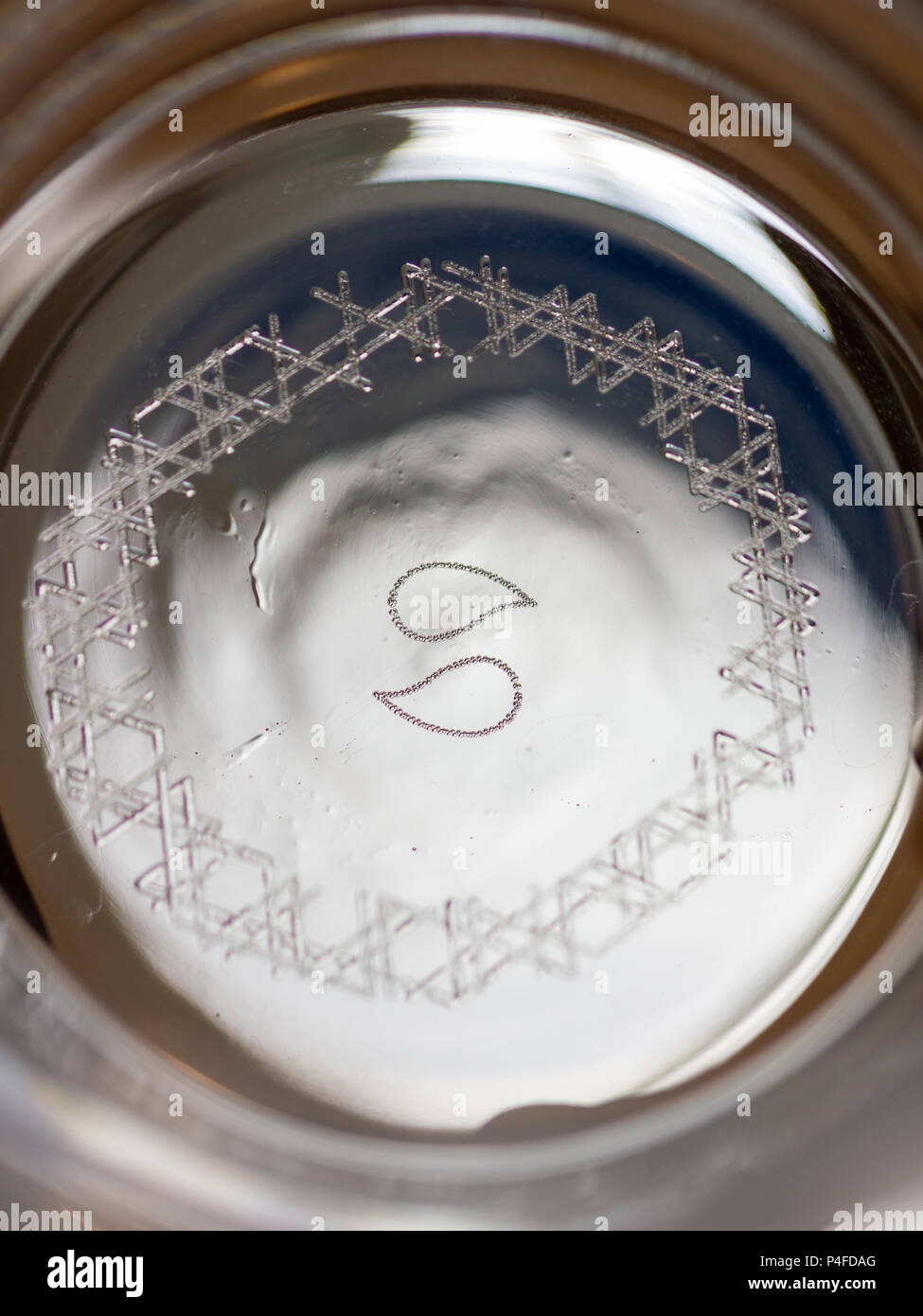 Nucleation marks engraved with a laser on the bottom of a glass to increase  carbonation of beer Stock Photo - Alamy