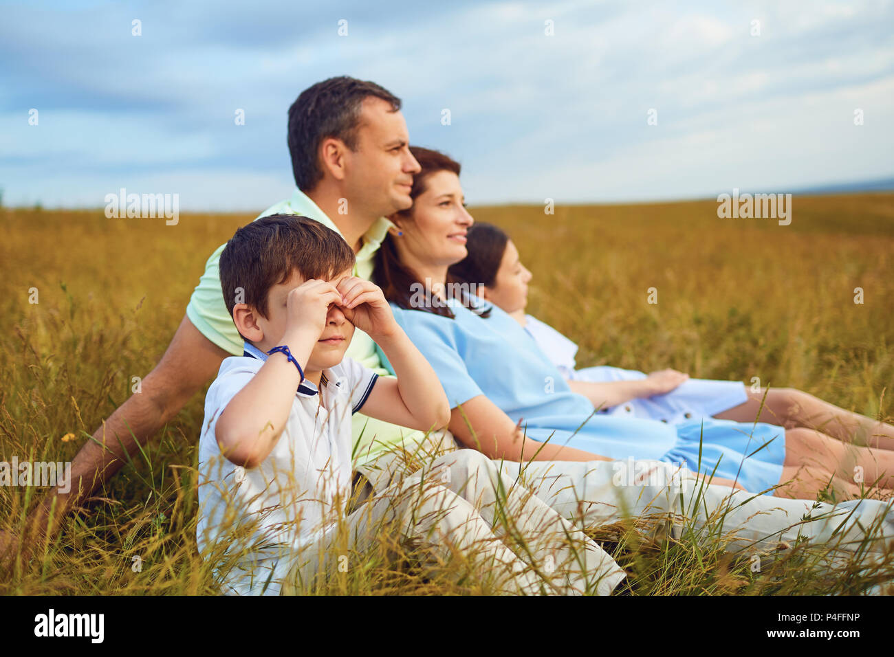 Family resting together sitting on grass in nature Stock Photo - Alamy