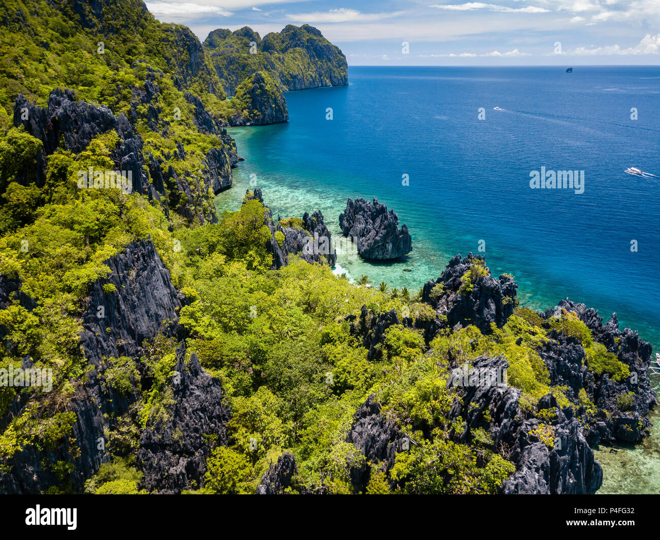 Aerial drone view of spectacular limestone cliffs, jungle, sandy beaches surrounded by coral reef Stock Photo