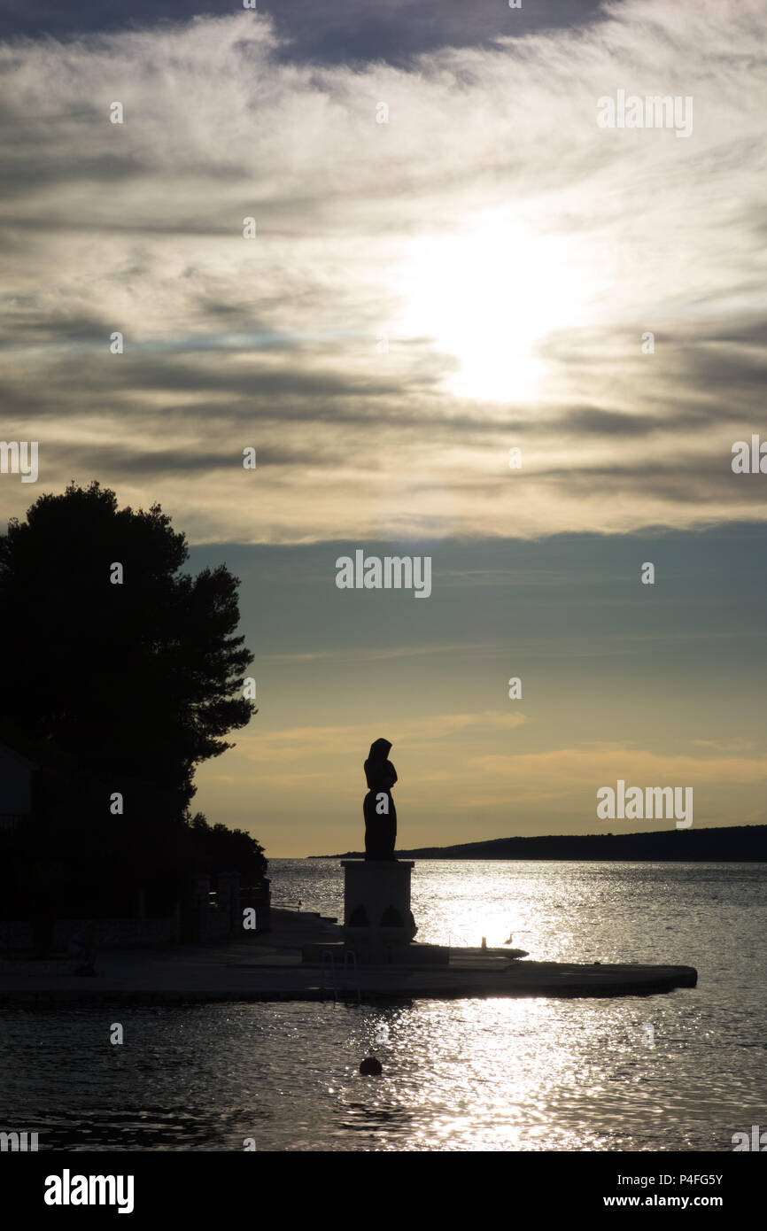 A statue on the island of Veliki Drvenik, Croatia, at sunset Stock Photo