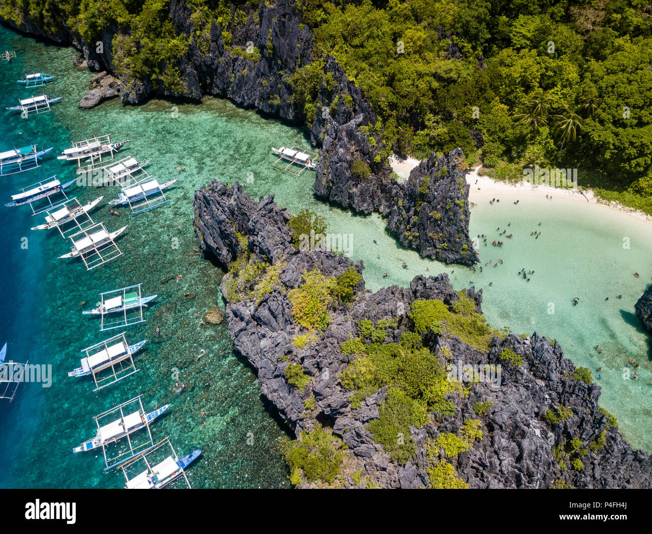 Aerial drone view of banca boats over a beautiful shallow tropical lagoon with sandy beach Stock Photo