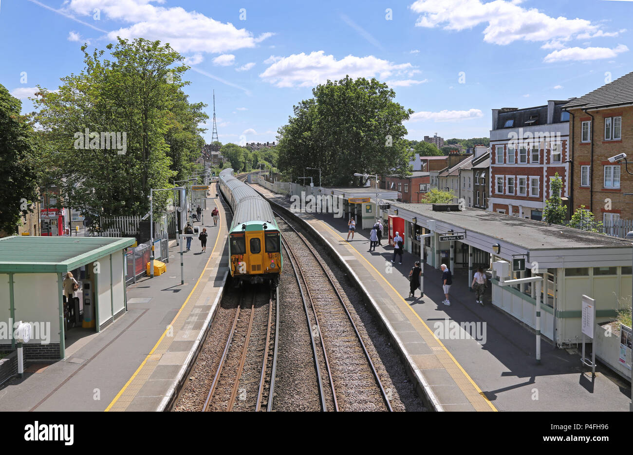 A Southern train departs from West Norwood Station towards Crystal Palace in South London. Summer day, shows passengers on platform. Stock Photo