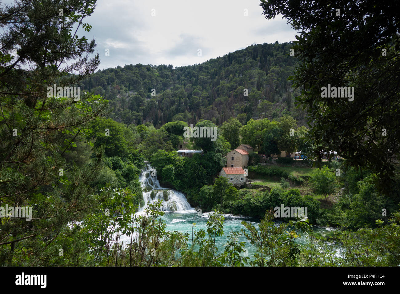 View of a waterfall and lake in Krka national park, Croatia, with a building in the background Stock Photo