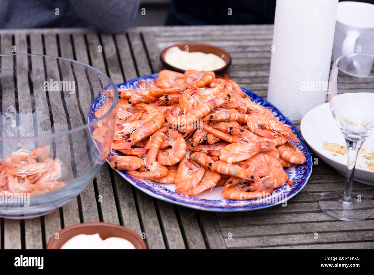 Friends sharing a plate of prawns at a social gathering outside Stock Photo