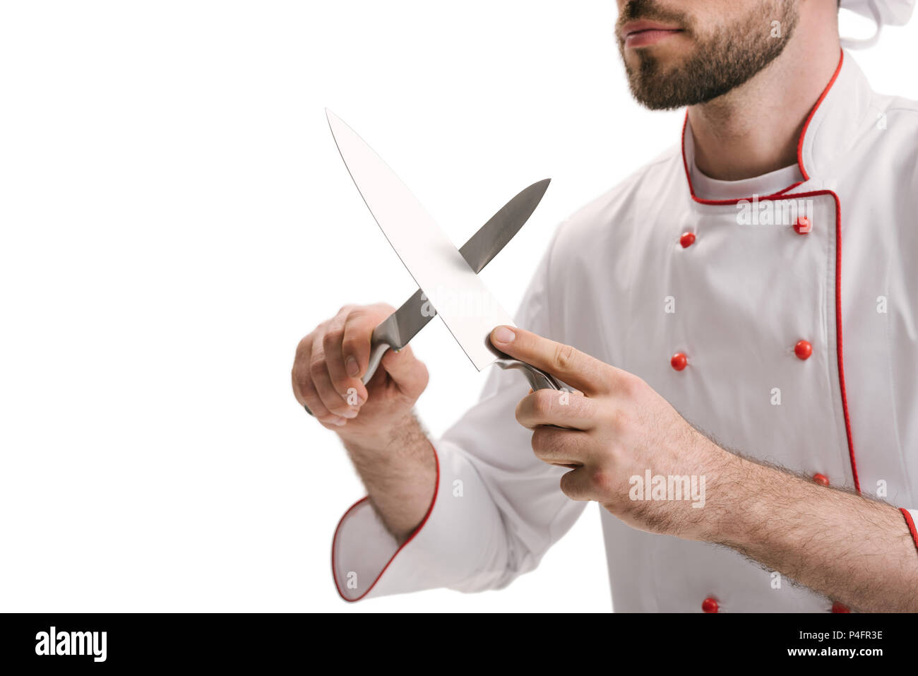 cropped shot of young chef sharpening knives isolated on white Stock Photo