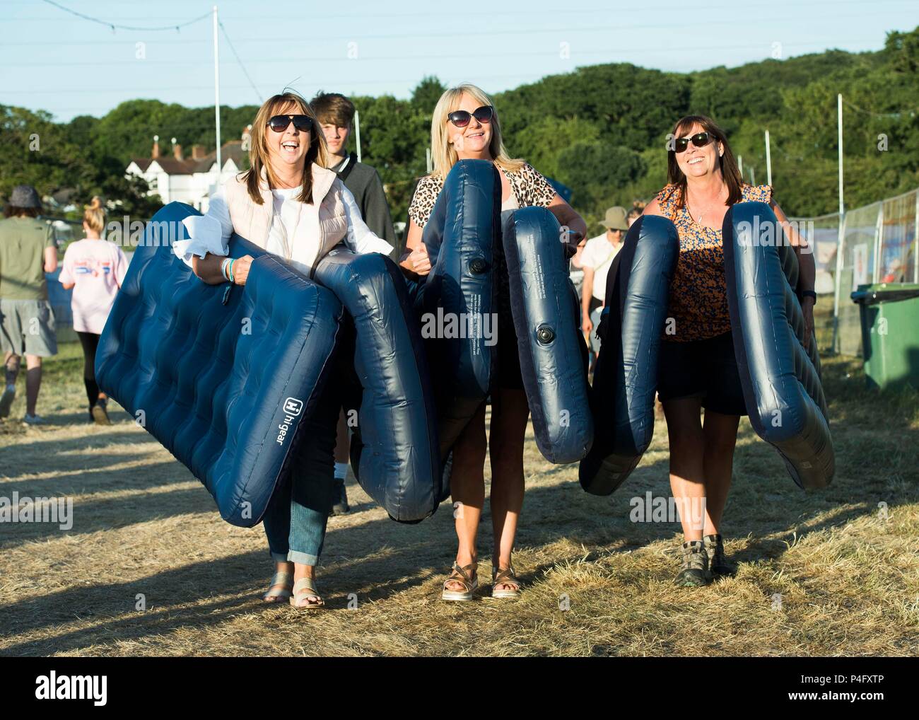 Heather Dockerty, April Beggs and Lorraine McAlister from Northern Ireland carry airbeds on site at the Isle of Wight festival at Seaclose Park, Newport. Stock Photo