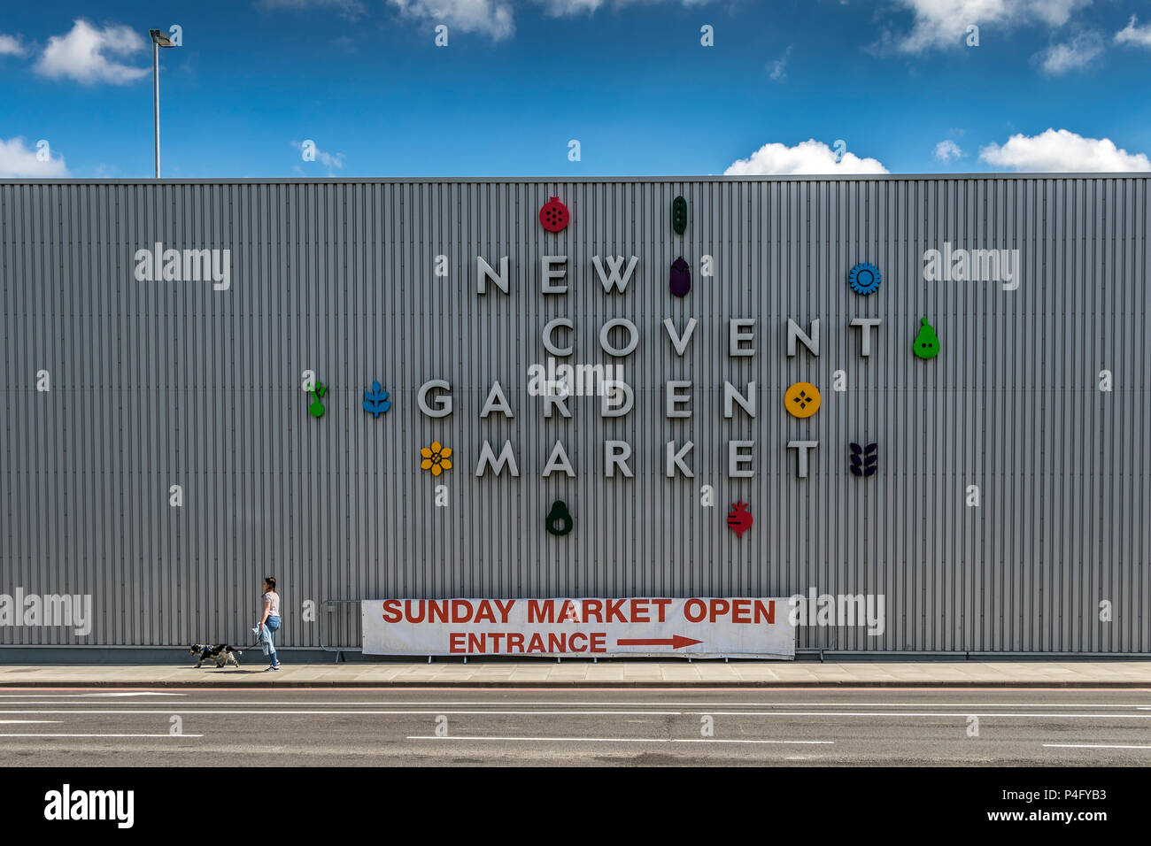 Girl with a dog walking past New Covent Garden Market ,the largest wholesale fruit, vegetable, and flower market in the United Kingdom , Nine Elms , Stock Photo