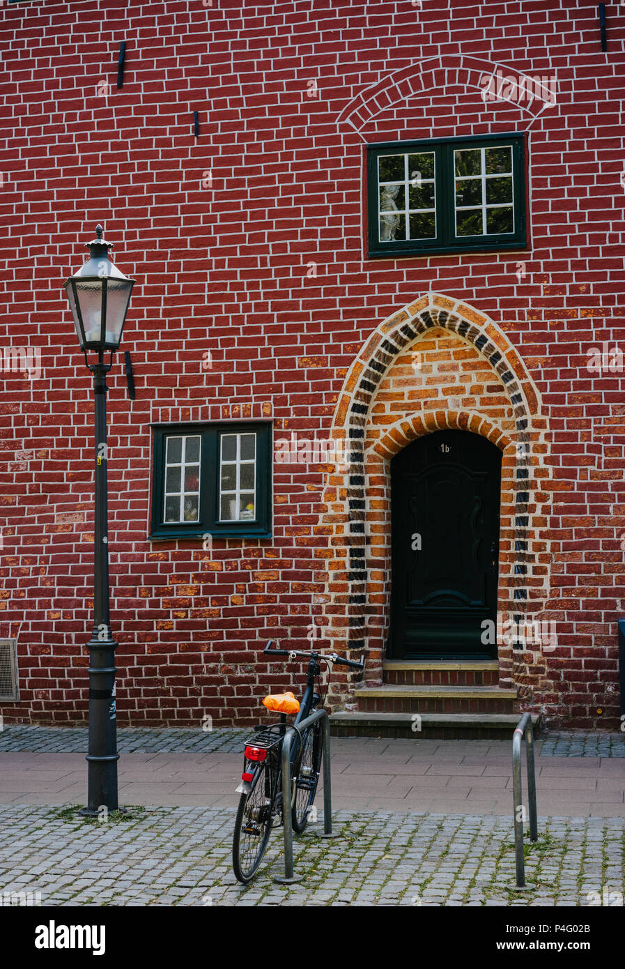 Traditional medieval german brick house in Luneburg, Germany. Fragment sticking out of the facade. Bicycle parked Stock Photo