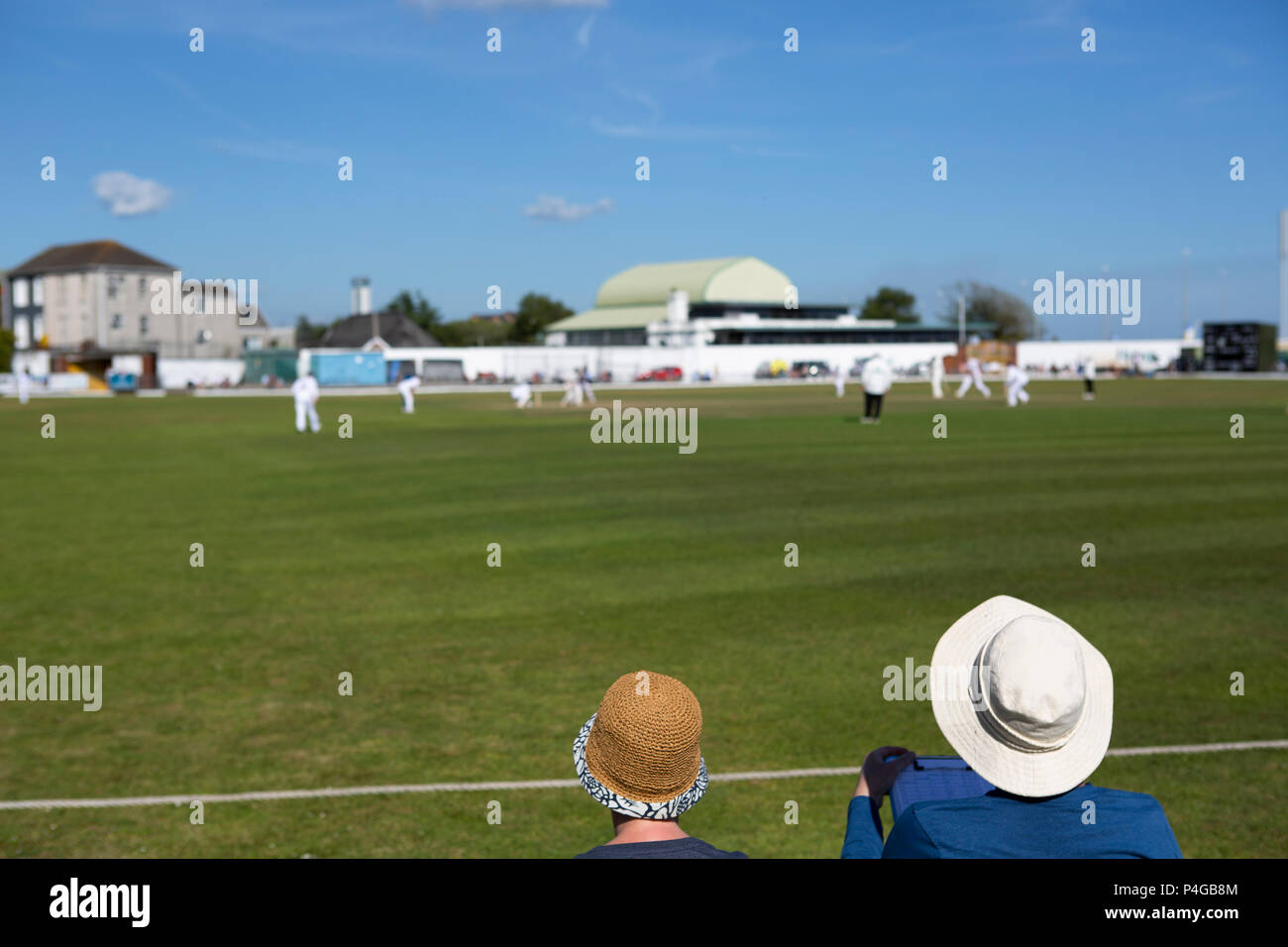 Two elderly ladies enjoy watching cricket on a hot day Stock Photo