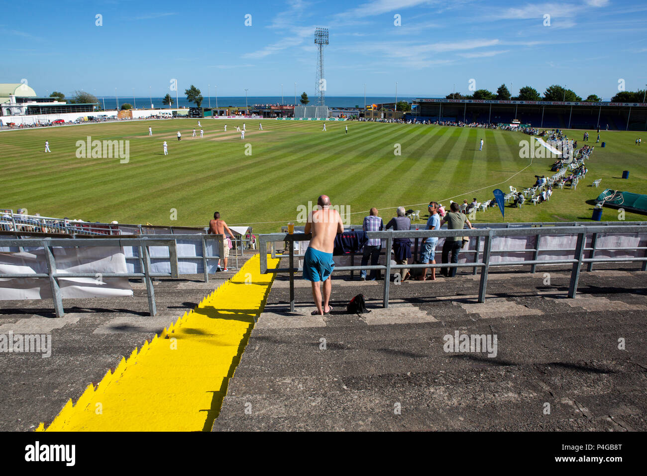 A spectator watches a first class county cricket match on a scorching hot day at Swansea Stock Photo
