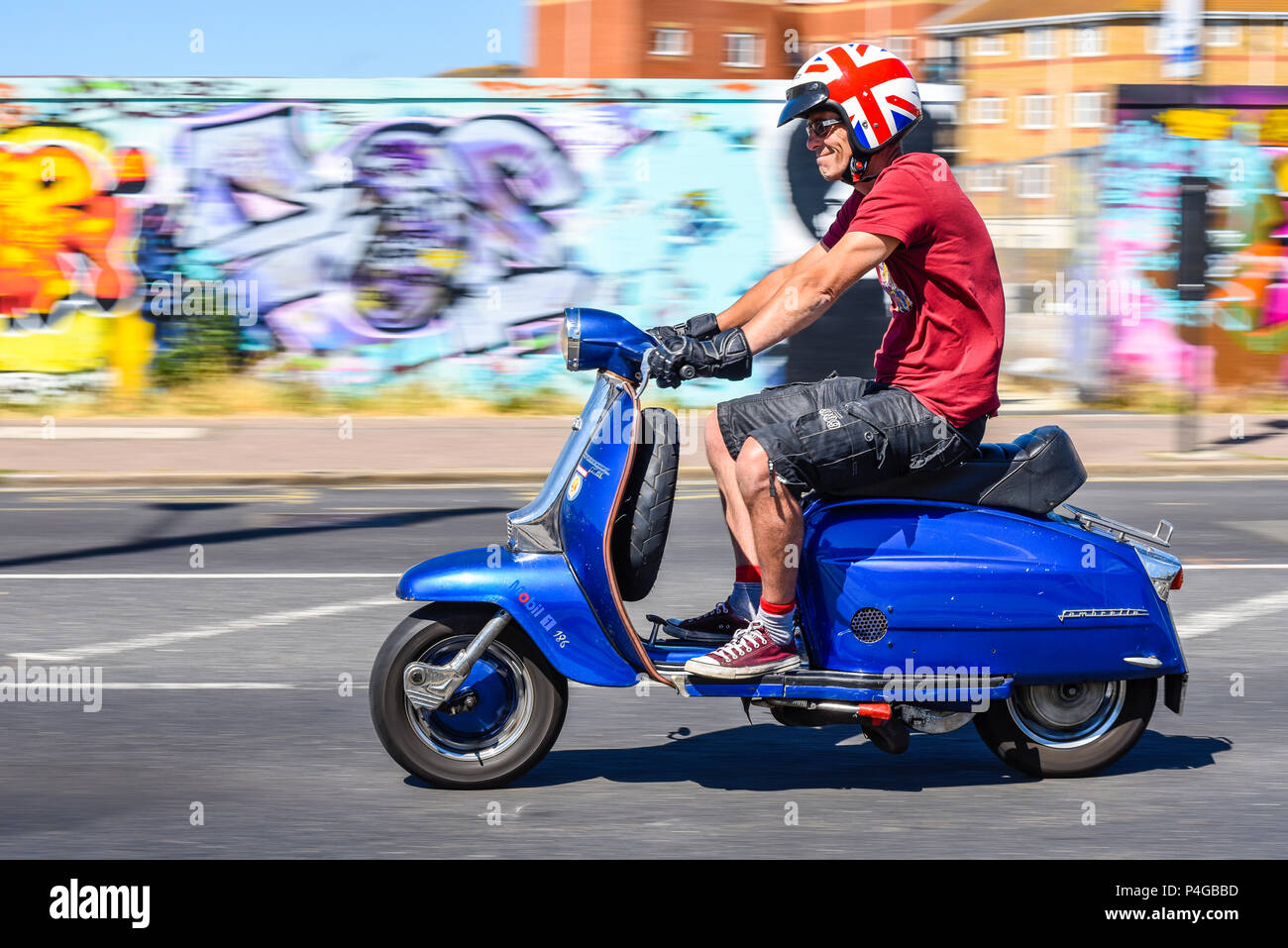 Lambretta Motor scooter rider with British Union Flag helmet riding along  Eastern Esplanade, Southend on Sea, Essex, UK. Sunny warm weather in  Southend. Bright colours graffiti Stock Photo - Alamy