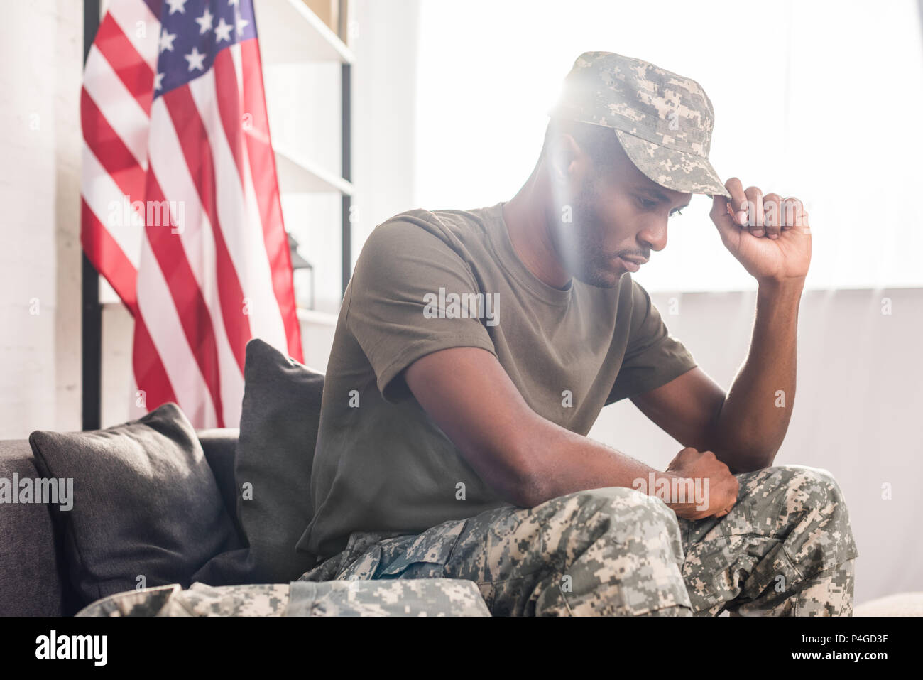 African american soldier in camouflage clothes sitting on sofa Stock Photo