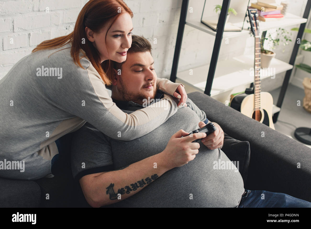 Happy boyfriend and girlfriend playing video games and holding