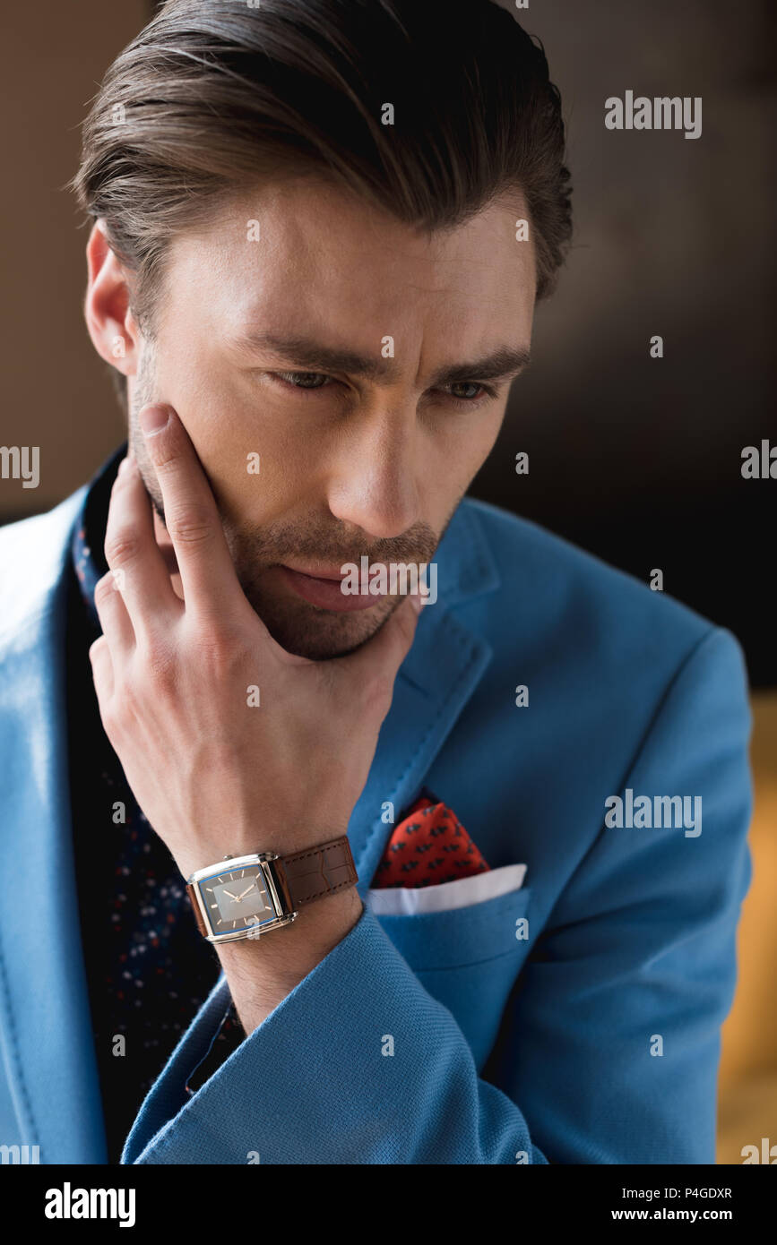 close-up portrait of thoughtful young man in stylish suit with ...