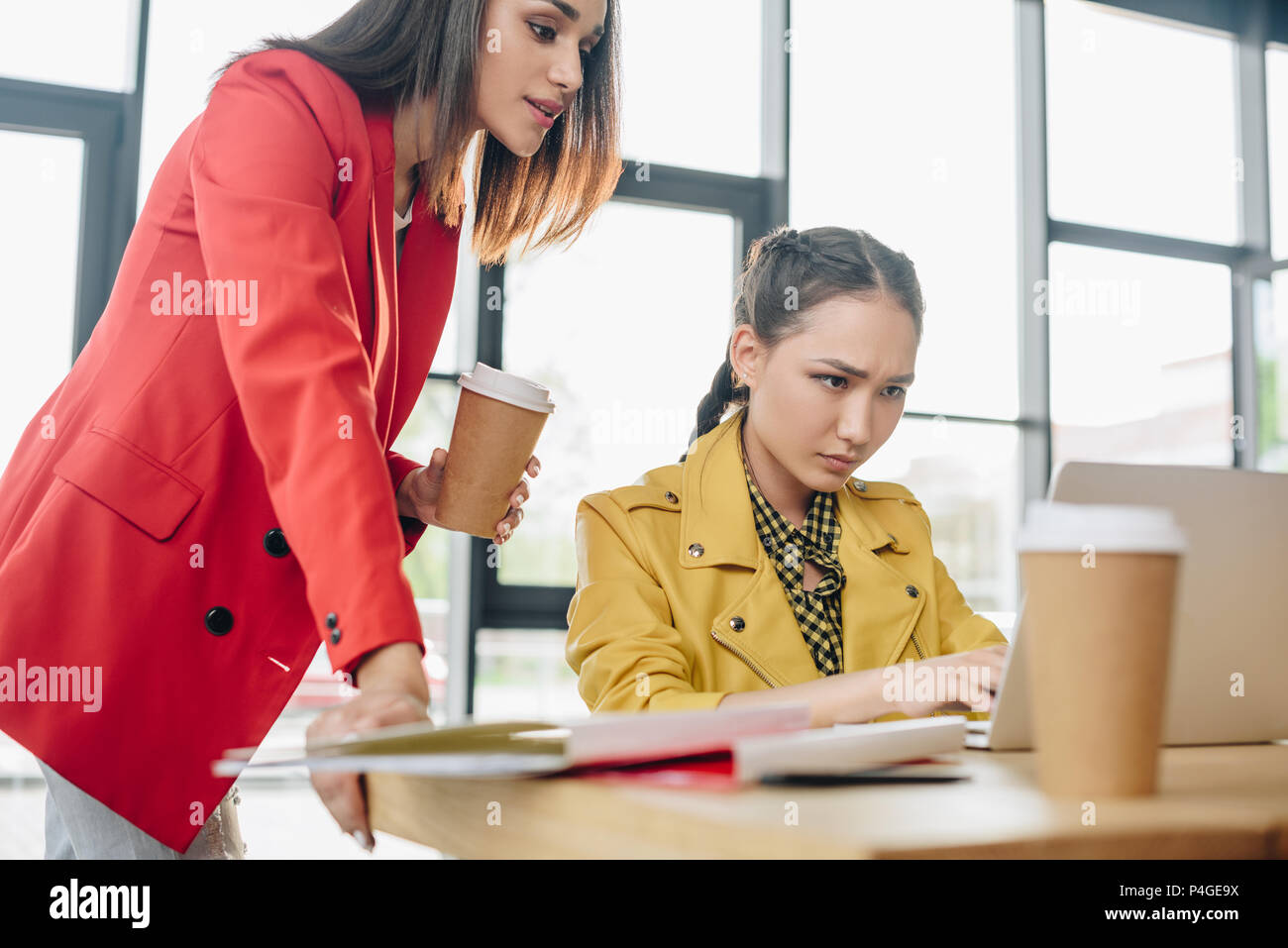 Professional businesswomen looking at laptop screen in modern office Stock Photo