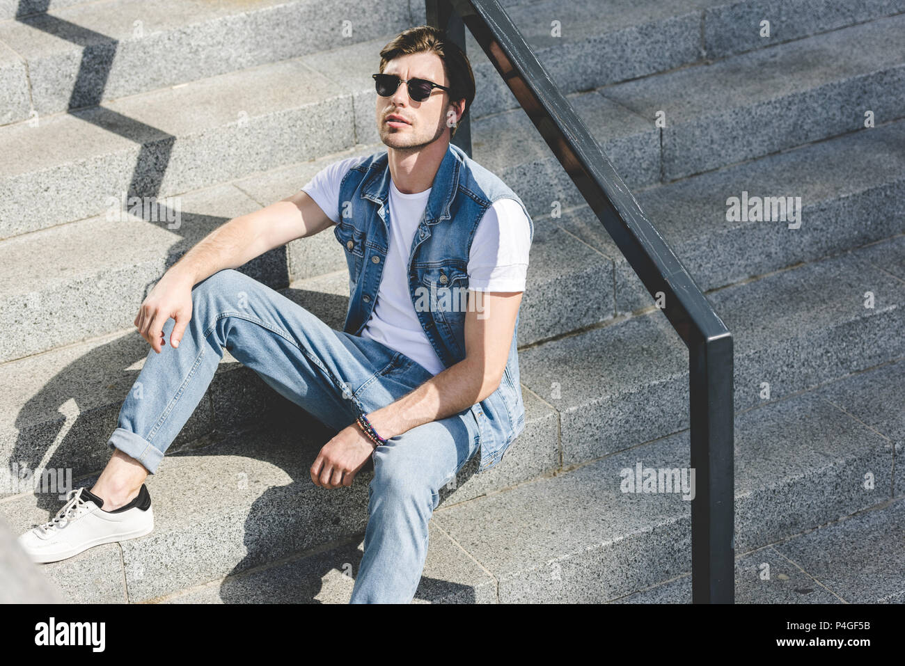 Young man sitting on stairs hi-res stock photography and images - Alamy