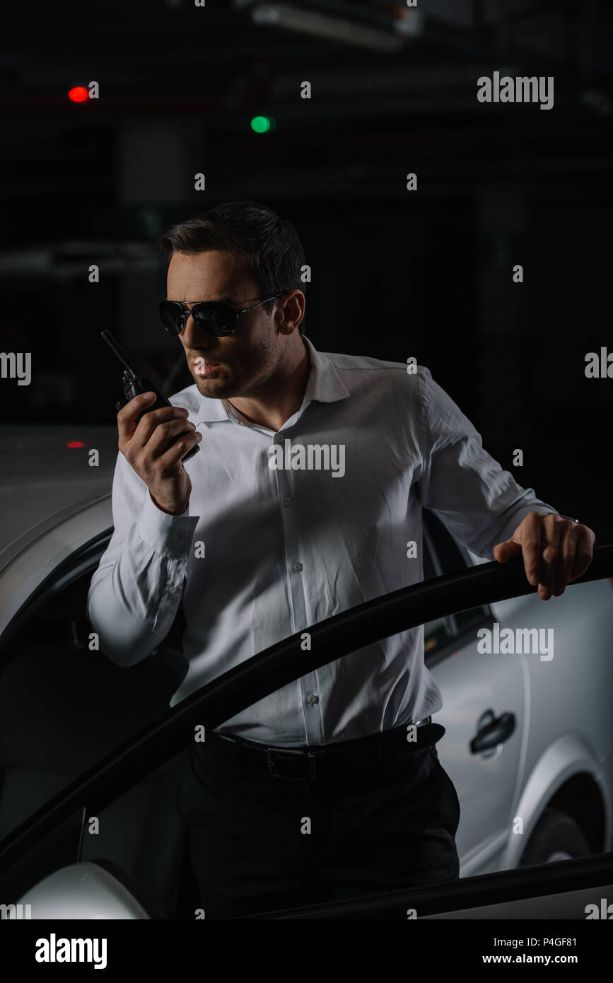 https://c8.alamy.com/comp/P4GF81/serious-male-undercover-agent-in-sunglasses-using-talkie-walkie-near-car-P4GF81.jpg