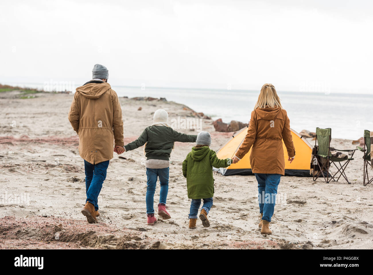 back view of family walking to camping tent on seashore Stock Photo Alamy