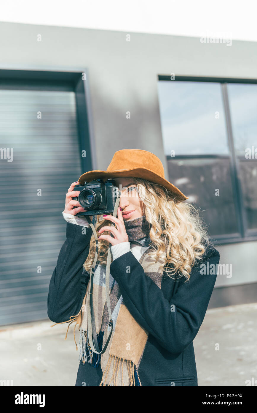 stylish young woman with camera photographing on street Stock Photo - Alamy