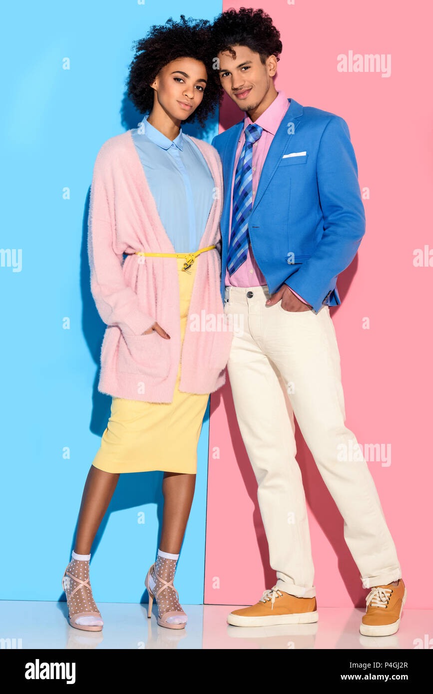 Young african amercian smiling girl and guy hugging on pink and blue background Stock Photo