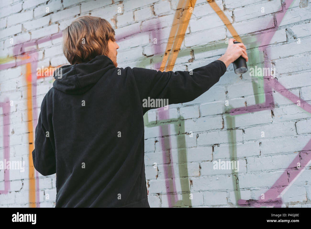 street artist painting colorful graffiti on wall of building Stock ...