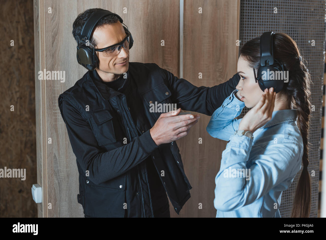 female client wearing ear muffs in shooting range Stock Photo