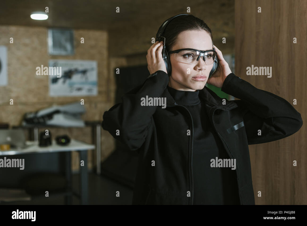 attractive girl wearing hearing protectors in shooting range Stock Photo