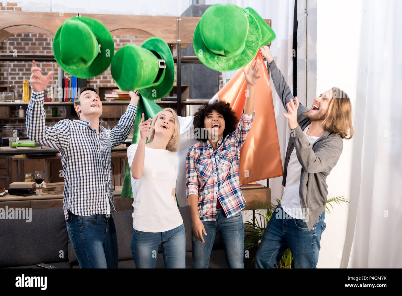 multicultural friends throwing up green hats on patricks day Stock