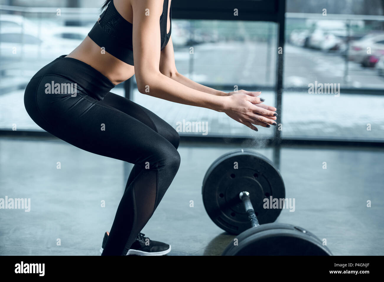 cropped shot of young sporty woman preparing to lift barbell at gym Stock Photo