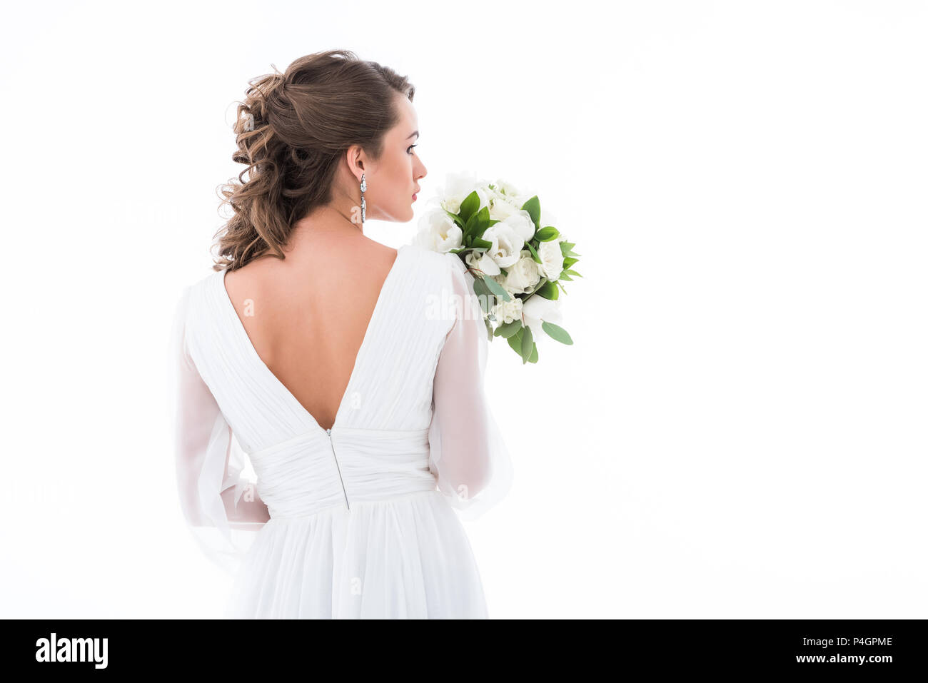 back view of bride in white dress holding wedding bouquet, isolated on white Stock Photo