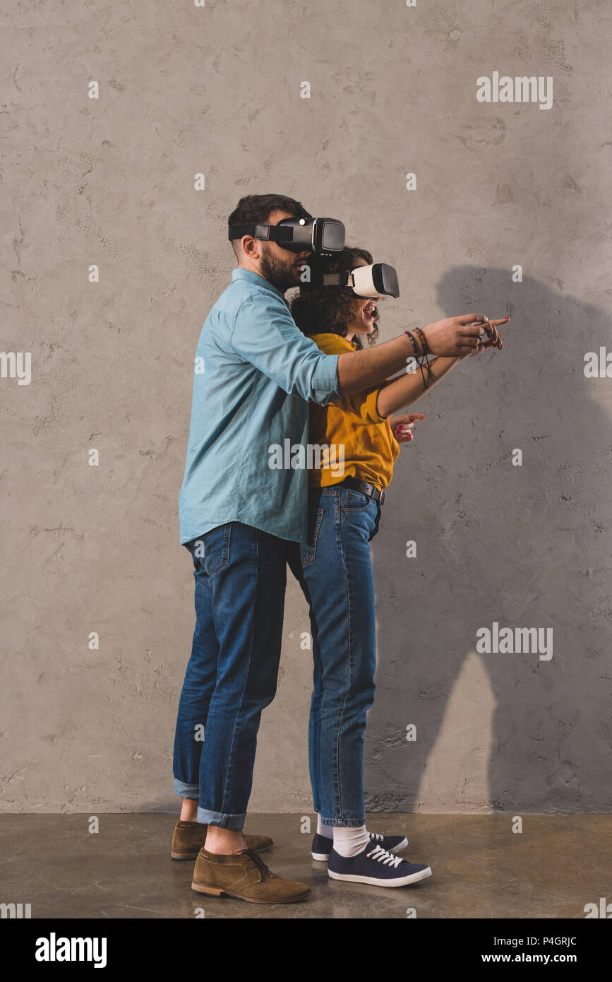 Couple standing and using virtual reality headset Stock Photo - Alamy