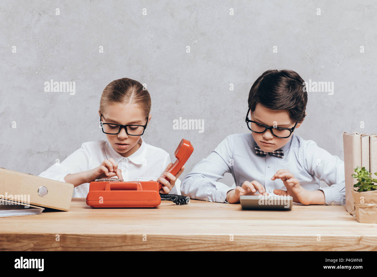 portrait of concentrated children in eyeglasses working together at workplace Stock Photo