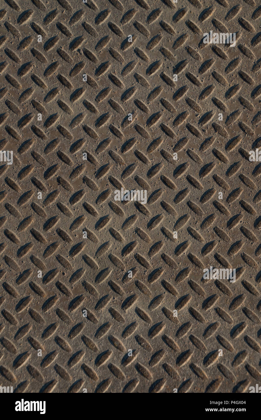Closeup of distressed, mottled, grungy industrial checker plate rusty metal background texture with diamond pattern wallpaper for construction, heavy  Stock Photo