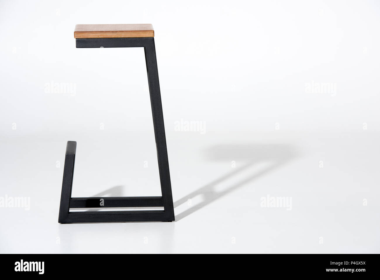 Studio shot of stylish barstool with wooden top and black metallic legs