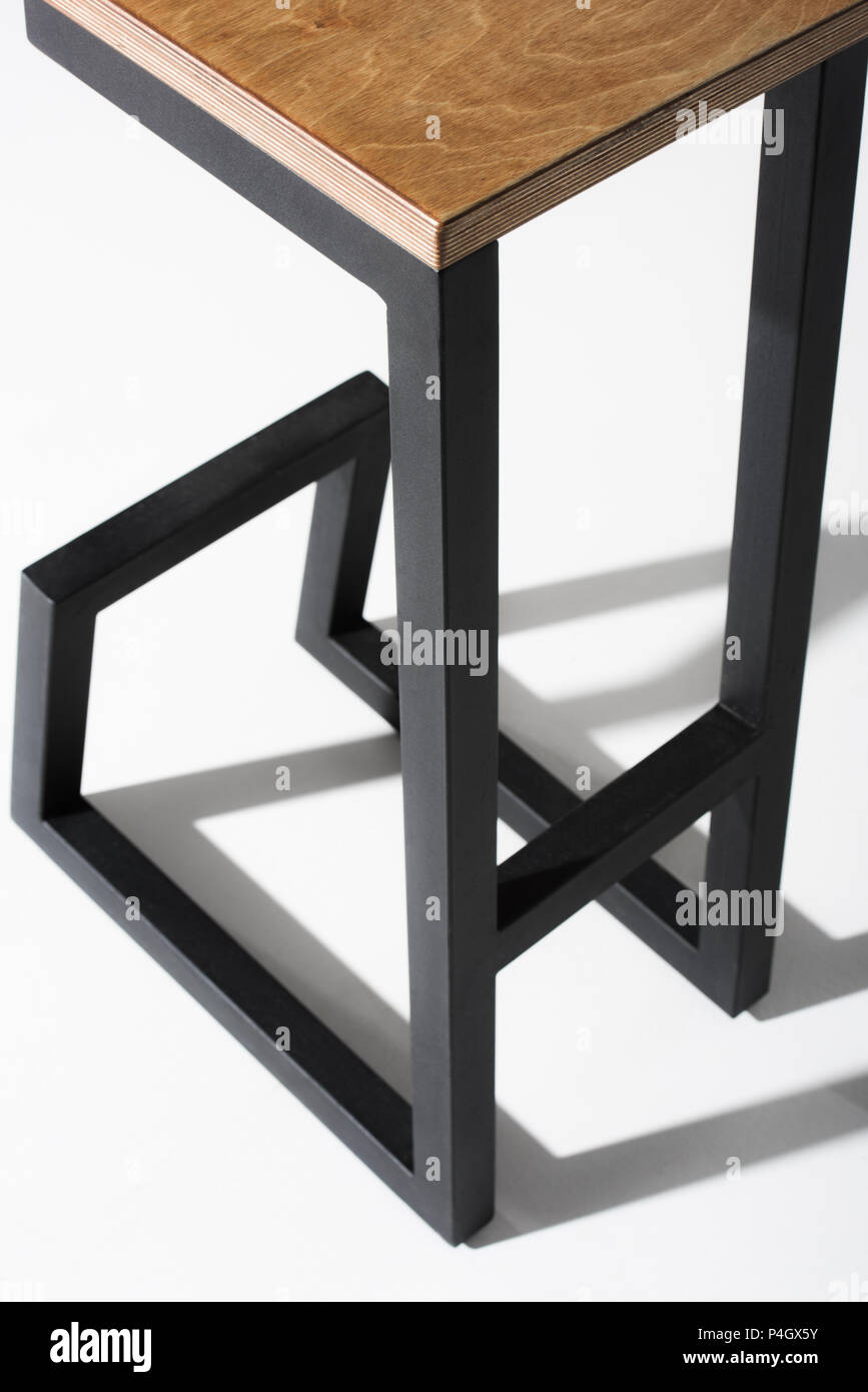 Studio shot of stylish barstool with wooden top and black metallic legs