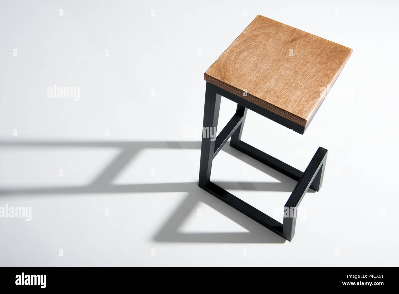 Studio shot of stylish barstool with wooden top and black metallic legs