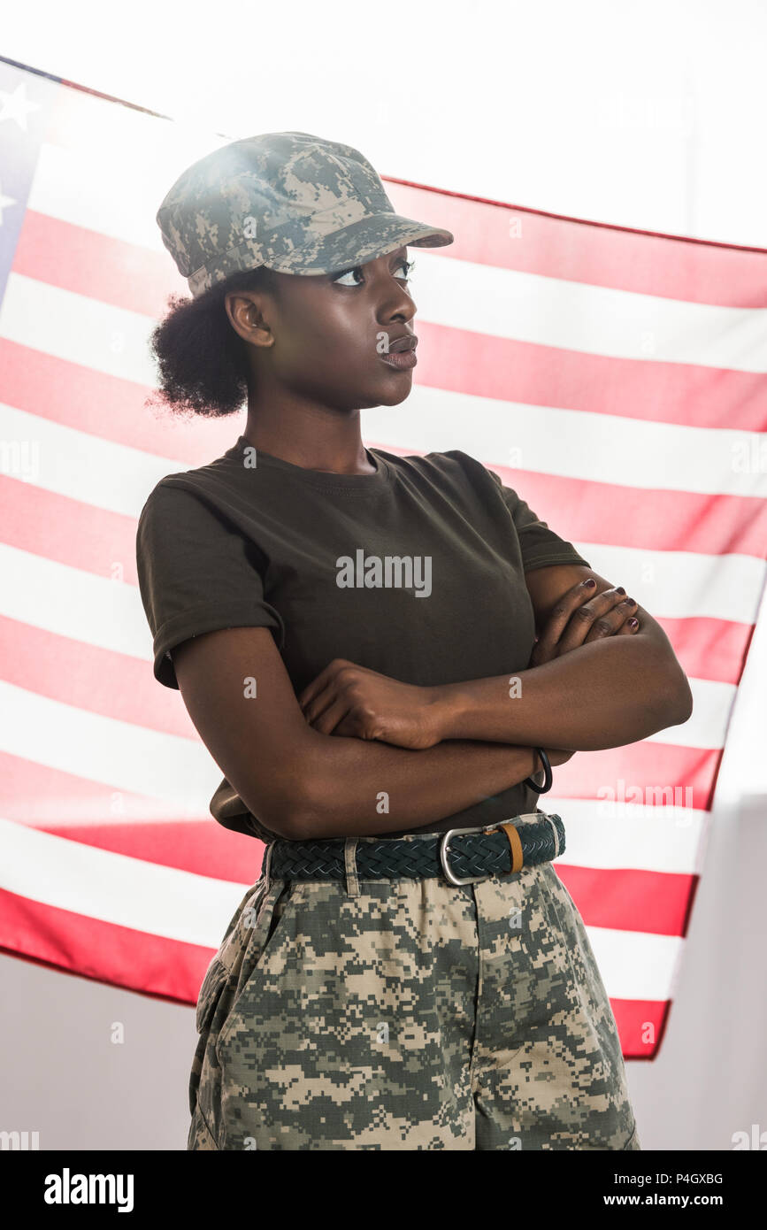 Young african american female soldier in camouflage clothes in front of us flag Stock Photo