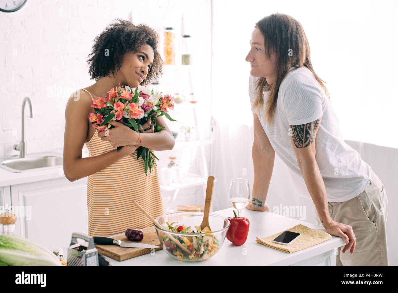 happy young african american woman holding bouquet of flowers and ...
