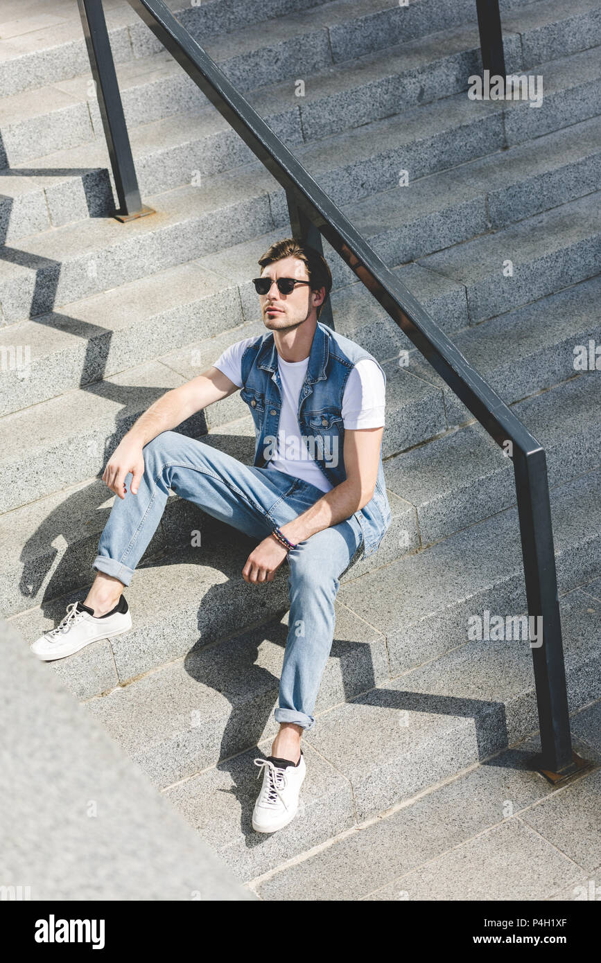 Young man sitting on stairs hi-res stock photography and images - Alamy
