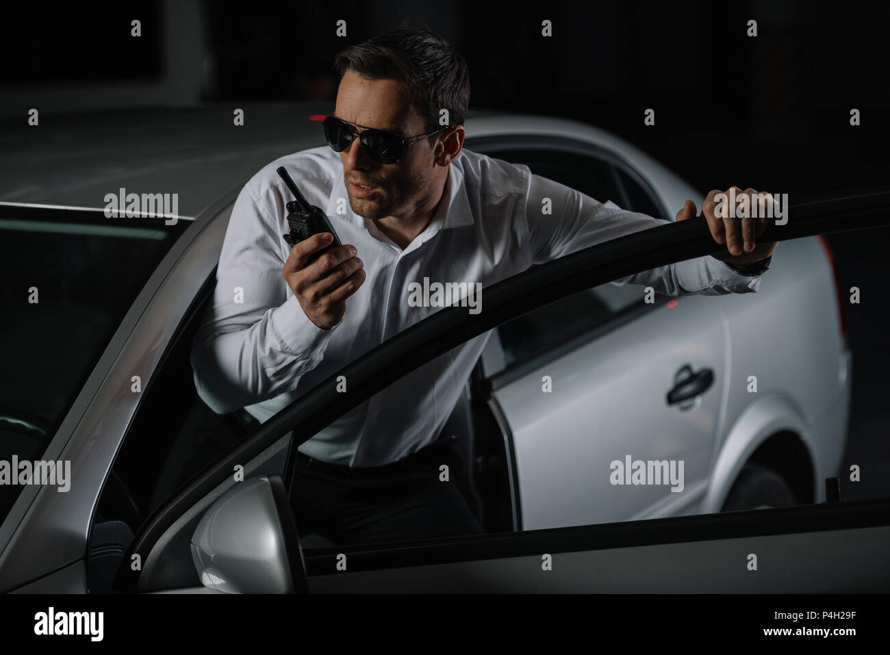 https://c8.alamy.com/comp/P4H29F/serious-male-undercover-agent-in-sunglasses-using-talkie-walkie-near-car-P4H29F.jpg