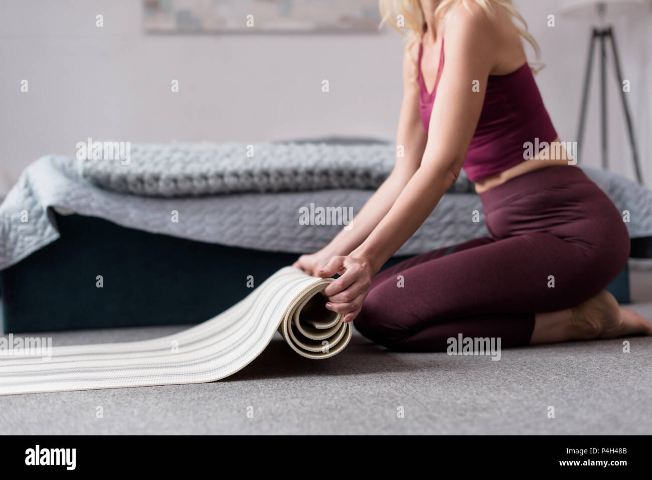 partial view of woman holding yoga mat at home Stock Photo - Alamy